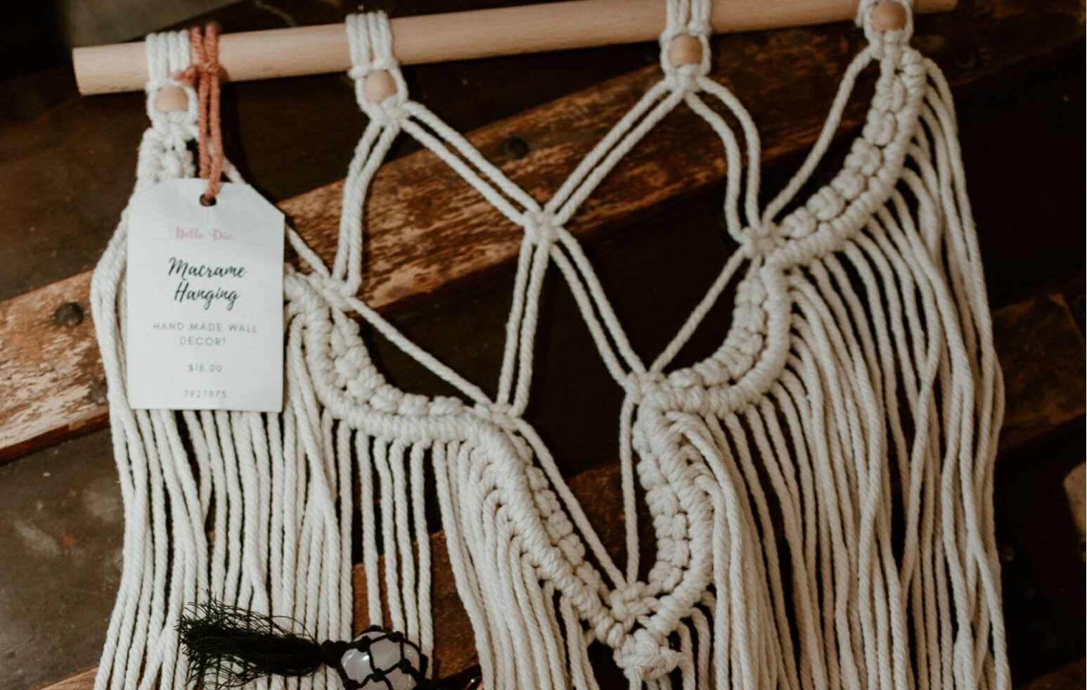 Macrame wall hanging with decorative elements on a wooden surface